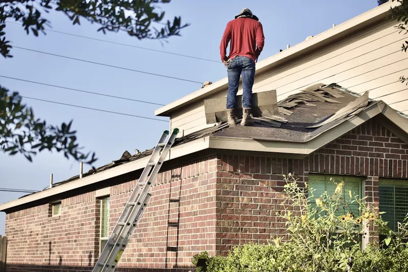 Professional roofer working on a residential roof in King Field